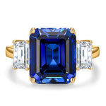 Emerald-Cut 5.5CT Royal Blue Lab-Grown Sapphire Engagement Ring – Three Stone Classic Design with Moissanite Side Stones, 14K Yellow Gold Plated on Tarnish-Resistant Silver（Includes GRC Certification from Gemstone Research Center）